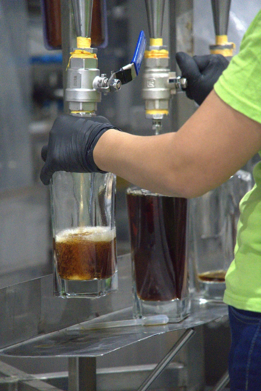 A gloved hand filling a bottle straight from the cask tap